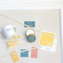 Load image into Gallery viewer, A beautifully arranged gift box designed for special occasions, featuring a vibrant greeting card with the empowering message "She Was Made of Sunlight," a zesty Ray of Sunshine Lemondrops, a calming soy candle, a playful and chic coffee mug, and a set of mini inspirational quote cards. Perfect for celebrating and uplifting your best gal or sending encouragement to someone special, reminding her of her amazing qualities and how much she's loved.